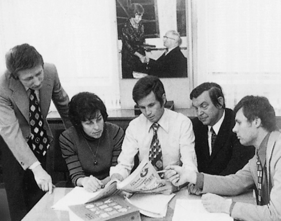 Fünf Personen am Schreibtisch